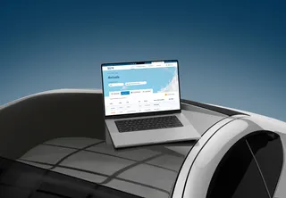 Malta International Airport flight website on a laptop placed on a modern curved structure